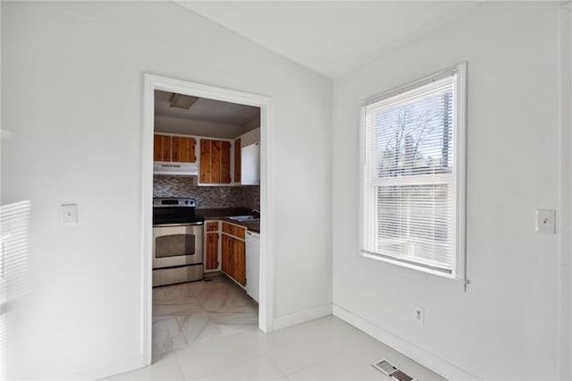 kitchen featuring electric range, light tile patterned floors, dishwasher, decorative backsplash, and sink