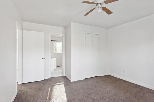 unfurnished bedroom featuring ensuite bath, a closet, carpet floors, and ceiling fan