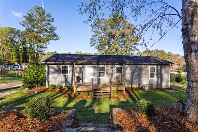 view of front of property with a wooden deck and a front lawn