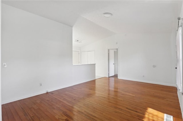 empty room with lofted ceiling and hardwood / wood-style floors