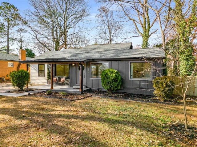 rear view of property with a yard and a patio area