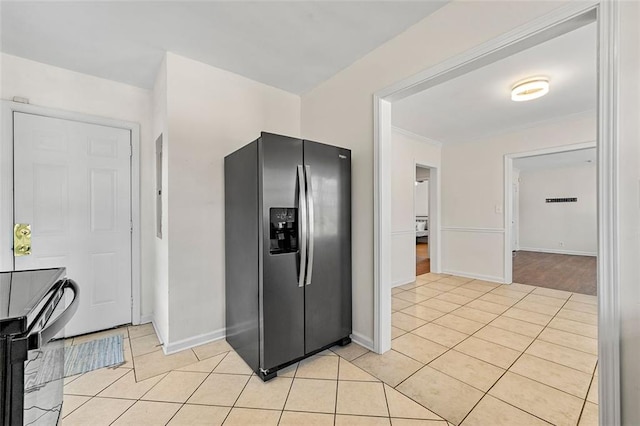 3723 Glenwood Rd, Decatur, GA 30032 - kitchen with stainless steel fridge, light tile patterned flooring, baseboards, ornamental molding, and black range with electric stovetop