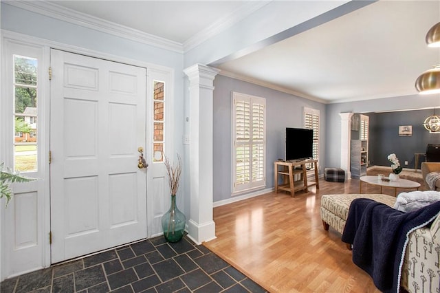 foyer with dark hardwood / wood-style flooring, ornate columns, plenty of natural light, and ornamental molding