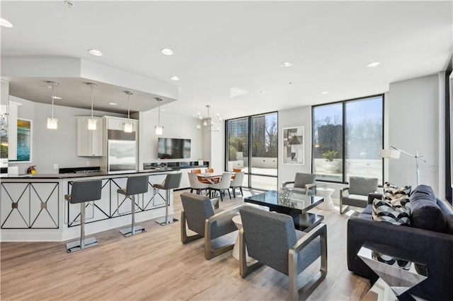 living area with light wood finished floors, recessed lighting, and floor to ceiling windows