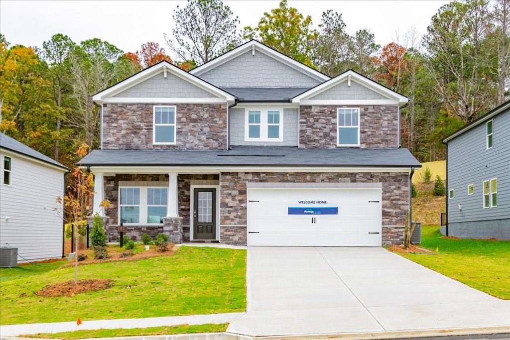 craftsman-style home with cooling unit, a front lawn, and a garage