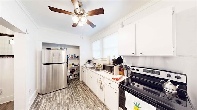 kitchen with sink, stainless steel appliances, crown molding, white cabinets, and light wood-type flooring