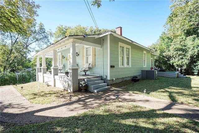 view of home's exterior with a porch, a yard, and central AC unit