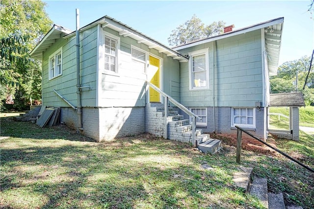 rear view of property featuring a lawn