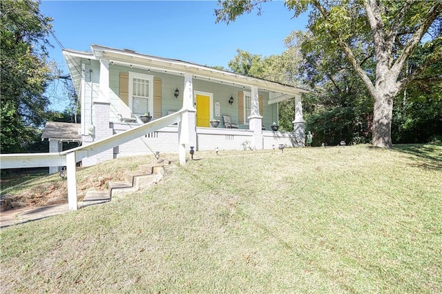 view of front of house with covered porch and a front lawn