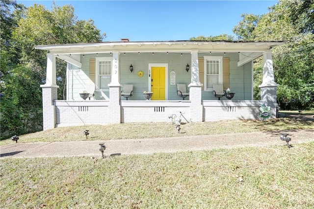 bungalow with a porch and a front lawn