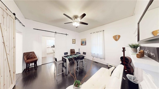 dining area featuring a barn door, a healthy amount of sunlight, and dark wood-type flooring