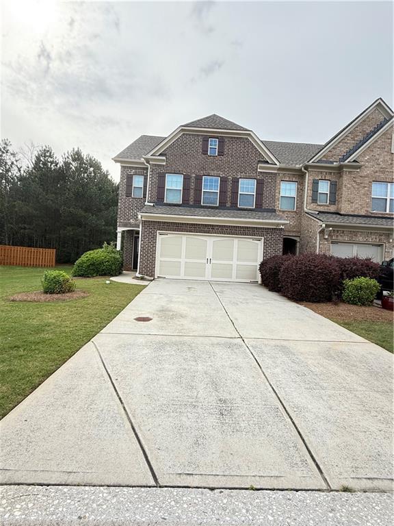 5850 Shiloh Woods Dr, Cumming, GA 30040 - view of front of house with driveway, a front lawn, a garage, and brick siding