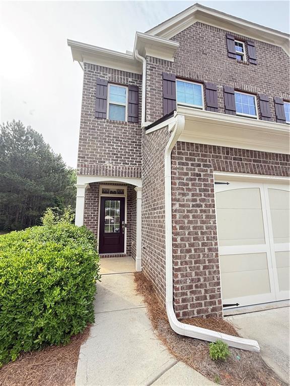 5850 Shiloh Woods Dr, Cumming, GA 30040 - view of exterior entry featuring brick siding and an attached garage