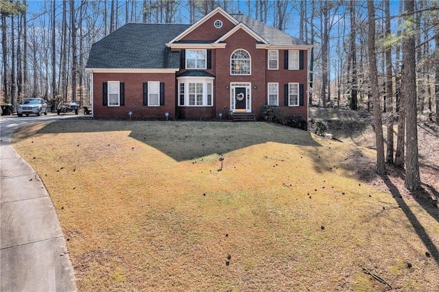 view of front of house featuring brick siding and a front lawn