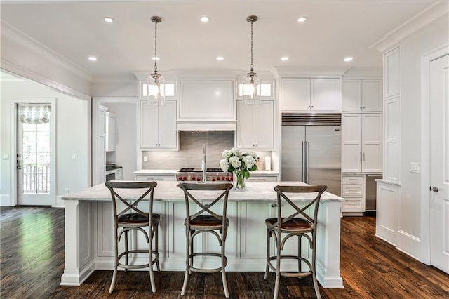 kitchen featuring white cabinetry, built in refrigerator, and custom range hood