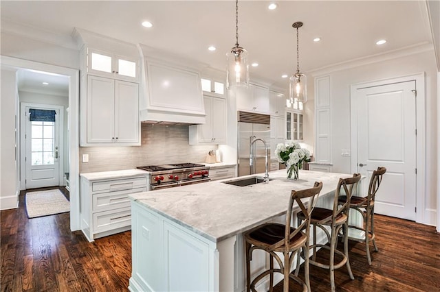 kitchen featuring ornamental molding, backsplash, a kitchen island with sink, premium appliances, and a sink