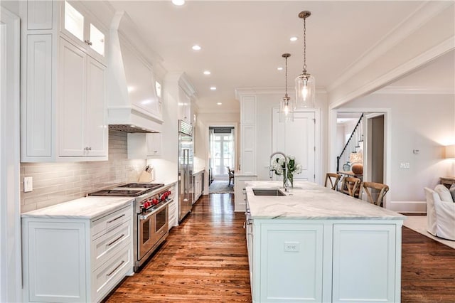 kitchen featuring custom exhaust hood, high quality appliances, wood finished floors, and a sink