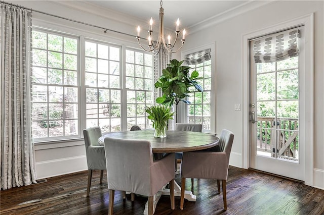 dining area featuring dark wood-type flooring, ornamental molding, plenty of natural light, and an inviting chandelier