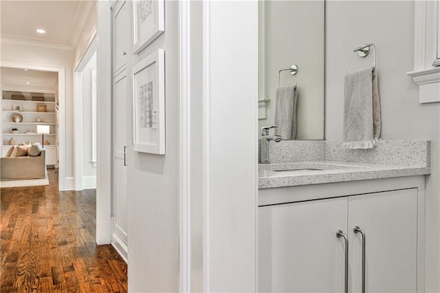 bathroom with ornamental molding, recessed lighting, vanity, and wood finished floors