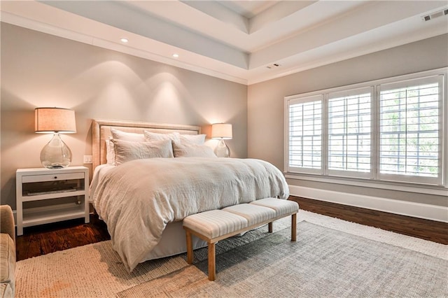 bedroom featuring visible vents, baseboards, multiple windows, and wood finished floors