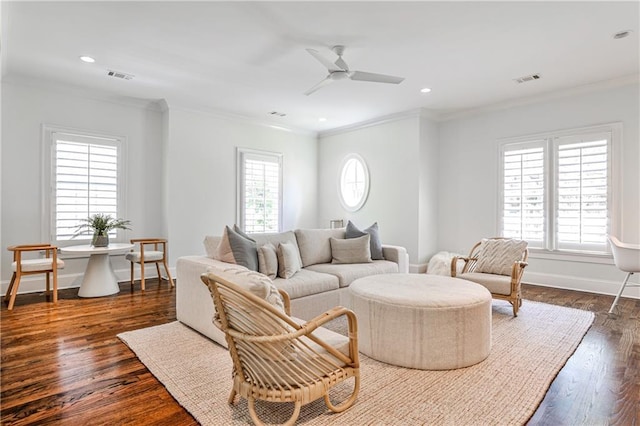 living area featuring crown molding, visible vents, a ceiling fan, and dark wood-type flooring