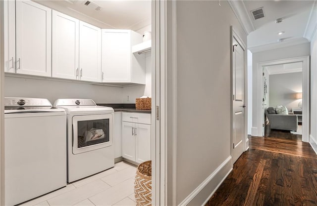 laundry room featuring crown molding, separate washer and dryer, visible vents, and cabinet space