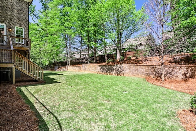 view of yard with fence and stairway