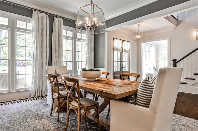 dining area with stairway, an inviting chandelier, crown molding, and wood finished floors