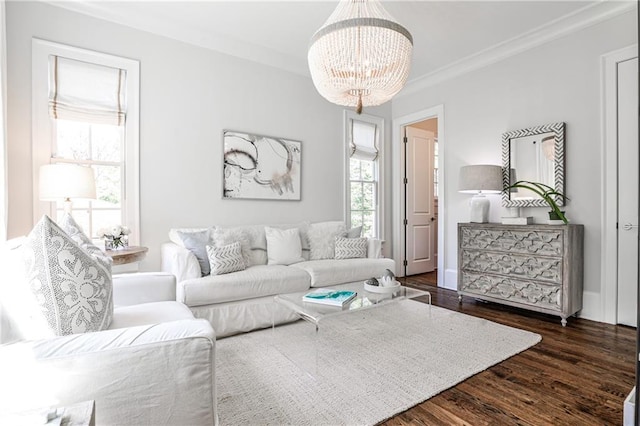 living room featuring dark wood-style floors, a notable chandelier, and ornamental molding