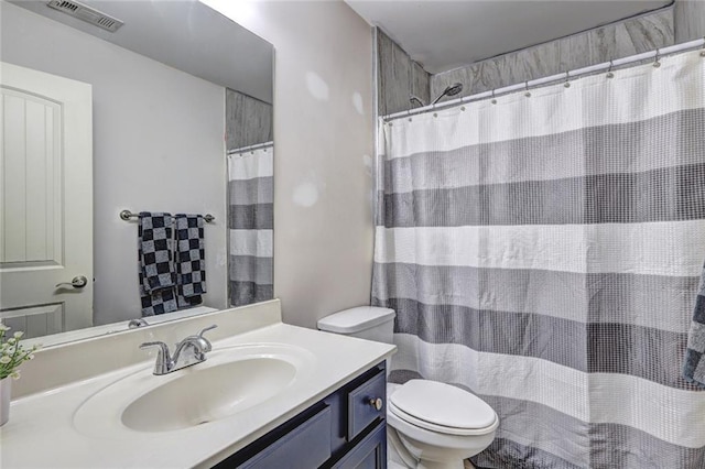 bathroom with vanity, toilet, and walk in shower