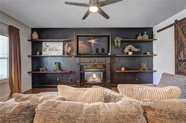 living room featuring a barn door, ceiling fan, and hardwood / wood-style flooring