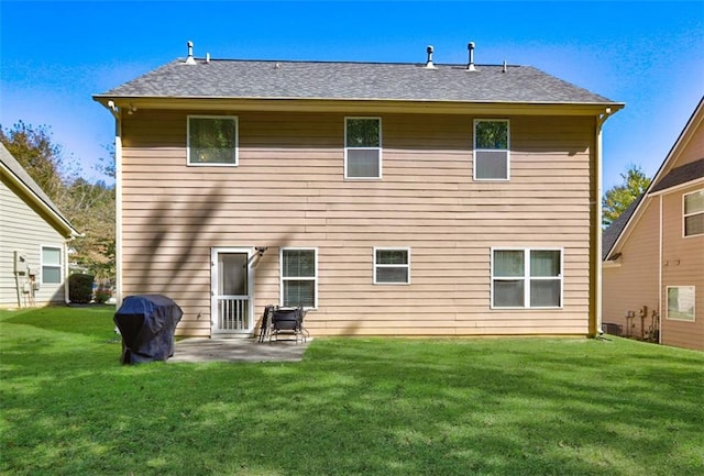 back of property with a lawn and a patio