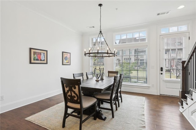 dining space with crown molding, dark hardwood / wood-style floors, and a chandelier