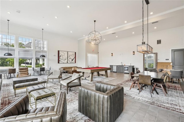 living room featuring crown molding, billiards, and a high ceiling