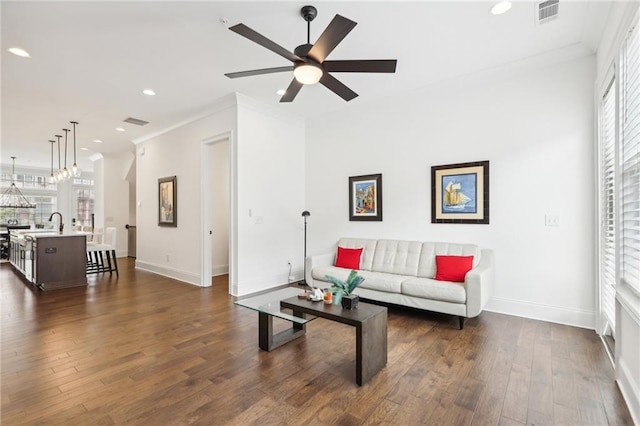 living room with crown molding, ceiling fan, and dark hardwood / wood-style floors