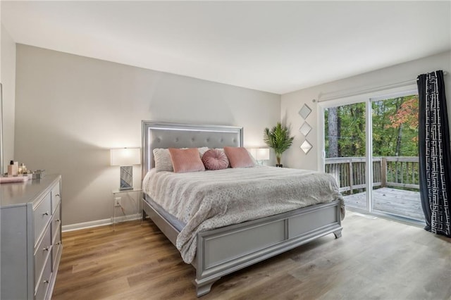 bedroom with light wood-type flooring, access to outside, and baseboards