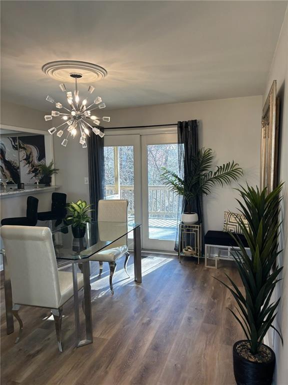 dining space featuring wood finished floors and a notable chandelier