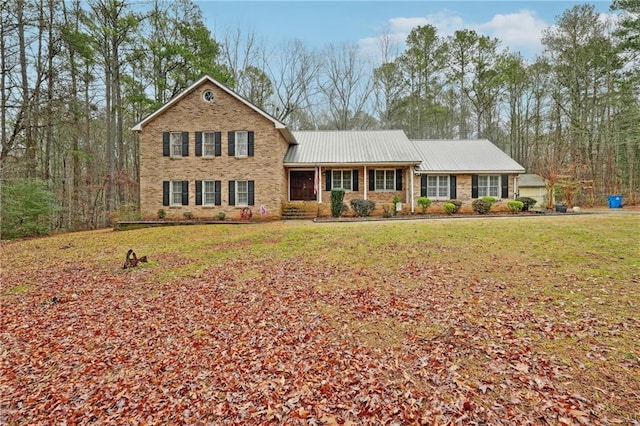 view of front of house with a garage, a front lawn, and covered porch