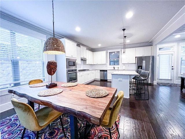 dining area featuring crown molding, sink, and dark wood-type flooring