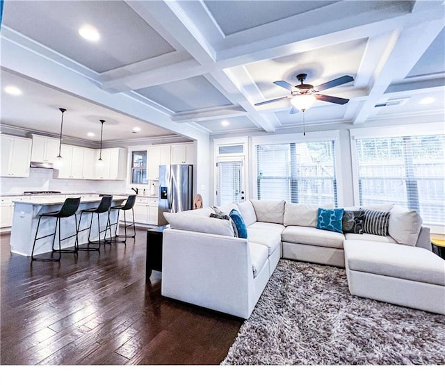 living room featuring beamed ceiling, dark hardwood / wood-style flooring, ceiling fan, and coffered ceiling