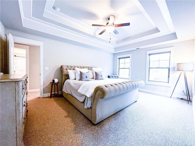 carpeted bedroom featuring ceiling fan and a tray ceiling