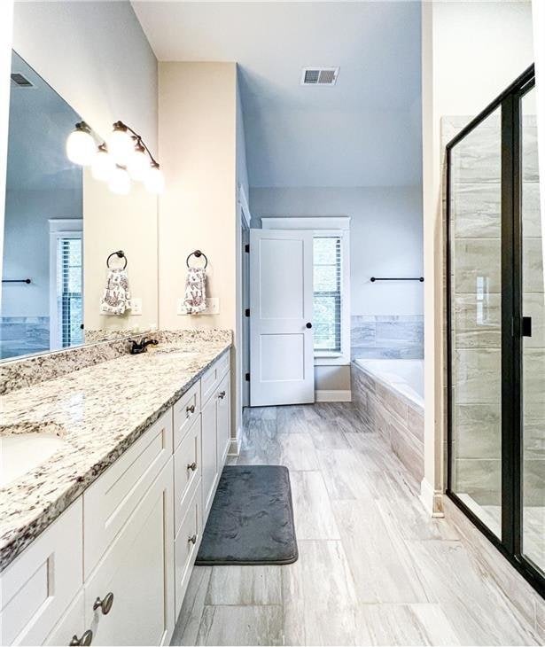 bathroom featuring plus walk in shower and vanity