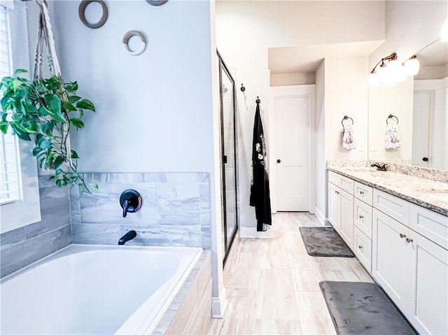 bathroom with vanity and shower with separate bathtub