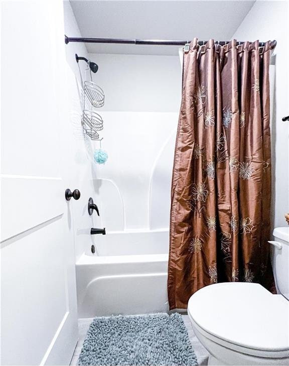 bathroom with tile patterned floors, toilet, and shower / bathtub combination with curtain