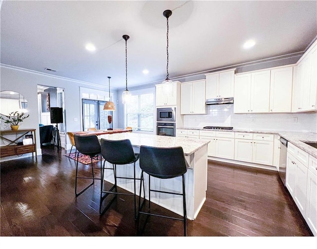 kitchen featuring white cabinets, crown molding, hanging light fixtures, and appliances with stainless steel finishes