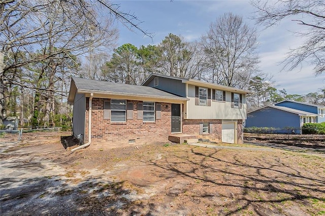 tri-level home with a garage and brick siding