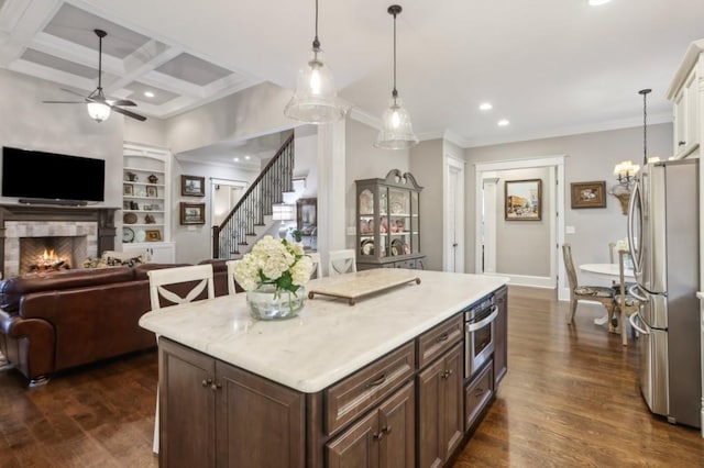 kitchen with stainless steel appliances, open floor plan, recessed lighting, ornamental molding, and light countertops