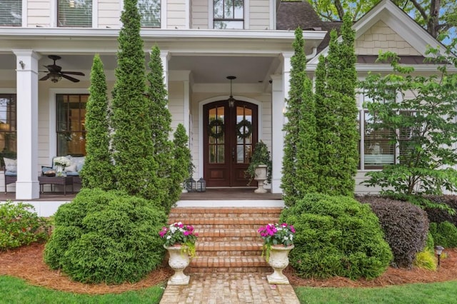 doorway to property featuring french doors, covered porch, and a ceiling fan