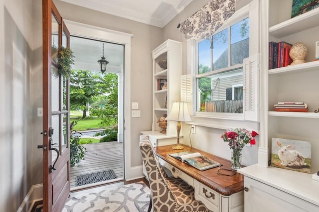 entryway with healthy amount of natural light, a desk, crown molding, and wood finished floors