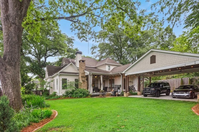 rear view of property featuring a chimney and a carport